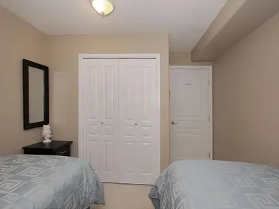 a bedroom with a bed and a white door at Deluxe 2 Bed 2 Bath With Harbour And Empress Hotel Views in Victoria