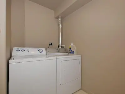 a washing machine in a room with a sink at Deluxe 2 Bed 2 Bath With Harbour And Empress Hotel Views in Victoria