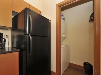 a black refrigerator in a kitchen next to a door at Gorgeous Luxury 2 Bedroom 2 Bath Condo In Old Town Victoria in Victoria