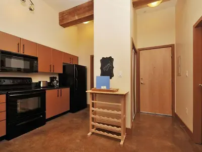 a kitchen with black appliances and a table with a box on it at Gorgeous Luxury 2 Bedroom 2 Bath Condo In Old Town Victoria in Victoria