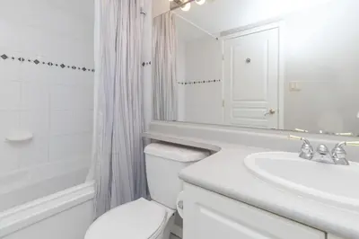 a white bathroom with a sink and a toilet at Deluxe 2 Bed 2 Bath And 5 Min Walk To Downtown And Seawalk in Victoria