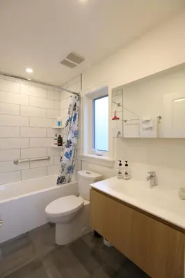 a bathroom with a toilet and a tub and a sink at Vancouver Traveller B&B in Vancouver