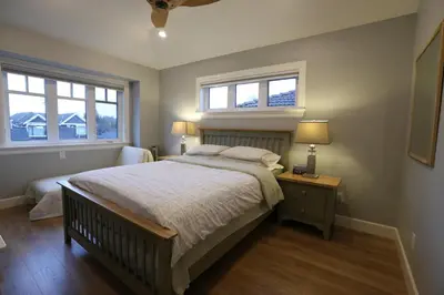 a bedroom with a large bed and two windows at Vancouver Traveller B&B in Vancouver