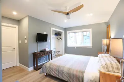 a bedroom with a bed and a flat screen tv at Vancouver Traveller B&B in Vancouver