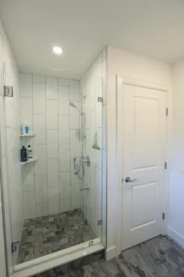 a bathroom with a shower with a glass door at Vancouver Traveller B&B in Vancouver