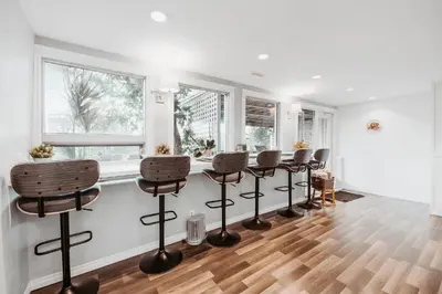 a bar with stools in a room with windows at Along River Ridge in Calgary