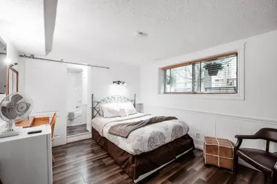 a bedroom with a bed and a desk and a window at Along River Ridge in Calgary
