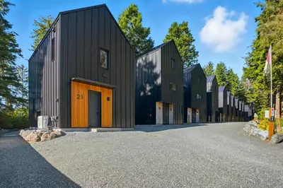 a row of black houses on a road at The Cabins at Terrace Beach in Ucluelet