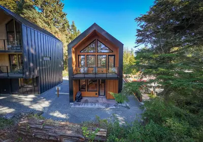 an image of a house with a large glass door at The Cabins at Terrace Beach in Ucluelet