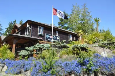 a house with a flag in front of it at The Cabins at Terrace Beach in Ucluelet