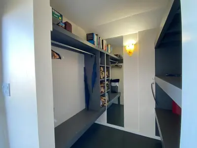 a room with a closet with shelves and a door at Woodhouse Cottages And Ranch in Prince George