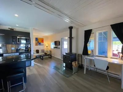 a living room with a kitchen and a living room with a stove at Woodhouse Cottages And Ranch in Prince George