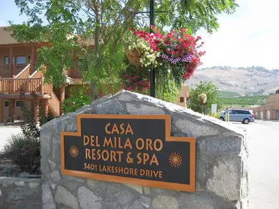 a sign for a restaurant and spa on a stone wall at Casa Del Mila Oro Condo in Osoyoos
