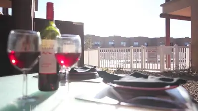 a table with two glasses and a bottle of wine at Casa Del Mila Oro Condo in Osoyoos