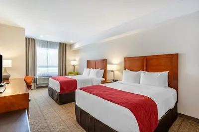 a hotel room with two beds and a desk at Comfort Inn & Suites in Valemount