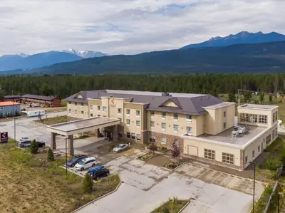 an aerial view of a building with mountains in the background at Comfort Inn & Suites in Valemount