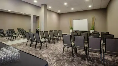 a conference room with a bunch of chairs and a whiteboard at Pomeroy Hotel & Conference Centre in Grande Prairie