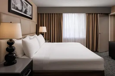 a hotel room with a large white bed and a window at Pomeroy Hotel & Conference Centre in Grande Prairie