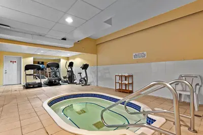 a fitness room with a hot tub and exercise equipment at Coast Fraser Inn in Williams Lake