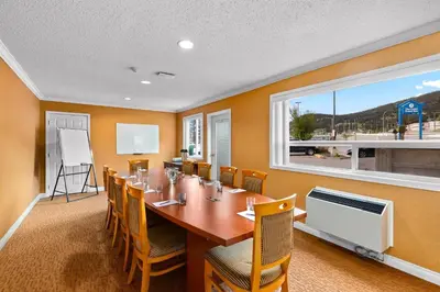a dining room with a table and chairs and a window at Coast Fraser Inn in Williams Lake