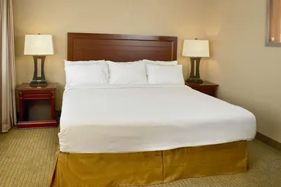 a large bed in a hotel room with two lamps at Coast Fraser Inn in Williams Lake