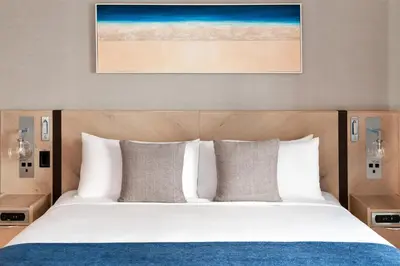 a bed with white sheets and pillows in a hotel room at Seaside Hotel North Vancouver in North Vancouver