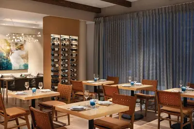 a restaurant with tables and chairs and wine racks at Seaside Hotel North Vancouver in North Vancouver