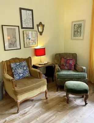 a living room with two chairs and a couch at Wisteria Guest House in Ganges