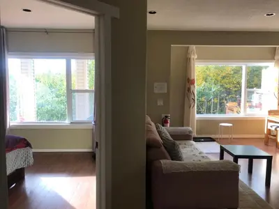 a living room with a couch and two windows at 民宿Ann's House in Calgary in Calgary