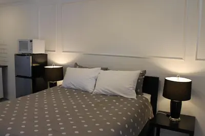 a bedroom with a bed with two lamps on tables at Sage Hills Motel in Cache Creek