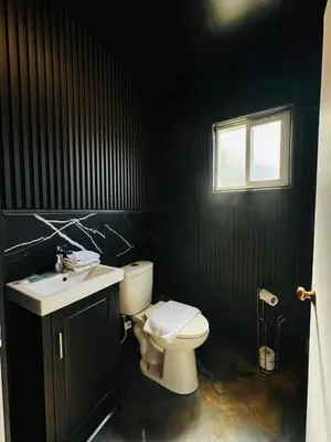 a bathroom with a toilet and a sink and a window at Sage Hills Motel in Cache Creek