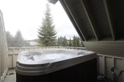 a large bath tub in a room with a window at Lagoons Condos by Whistler Retreats in Whistler