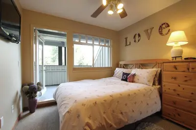 a bedroom with a bed and a dresser and a window at Lagoons Condos by Whistler Retreats in Whistler