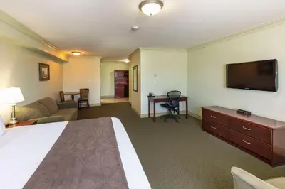 a hotel room with a bed and a flat screen tv at Quality Inn & Suites in Whitecourt