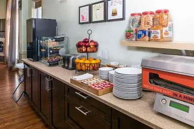 a kitchen with a counter with plates and food at Quality Inn & Suites in Whitecourt