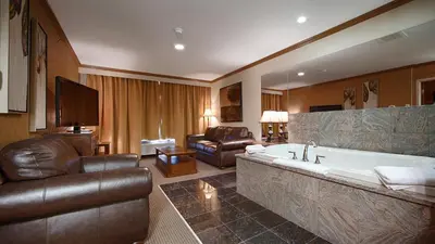 a living room with a large tub and a couch at Camrose Resort Hotel in Camrose