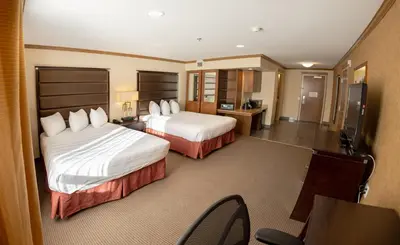 a hotel room with two beds and a television at Camrose Resort Hotel in Camrose