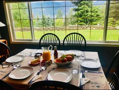 a wooden table with a bowl of fruit and a window at The Blue House Bed and Breakfast in Lake Country