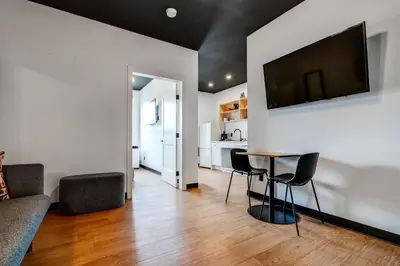 a living room with a table and a television on a wall at Raven Inn Whitehorse in Whitehorse