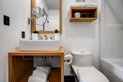 a bathroom with a sink and a toilet and a mirror at Raven Inn Whitehorse in Whitehorse