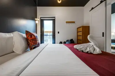 a bedroom with a large white bed with a red rug at Raven Inn Whitehorse in Whitehorse