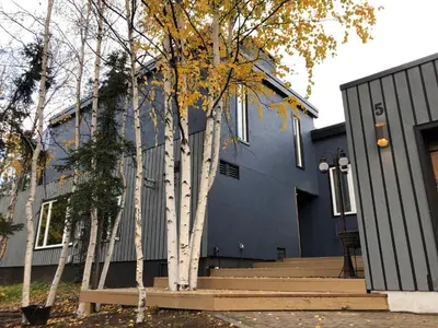 a blue house with trees in front of it at \u597d\u4e18\u3002Hacho House in Yellowknife