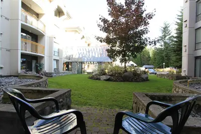 two benches sitting in a park in front of a building at Marquise Condos by Whistler Retreats in Whistler