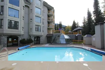 a large blue swimming pool in front of a building at Marquise Condos by Whistler Retreats in Whistler