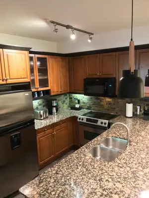 a kitchen with wooden cabinets and a granite counter top at Luxurious & Spacious Mountain Retreat in Canmore