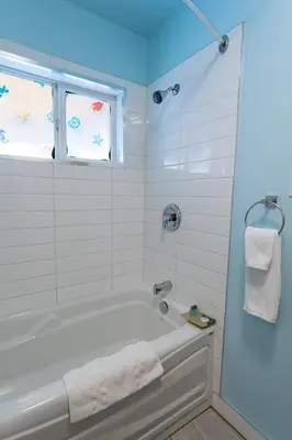 a white bathroom with a tub and a window at Ace Motel in Princeton