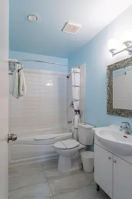 a bathroom with a toilet and a tub and a sink at Ace Motel in Princeton