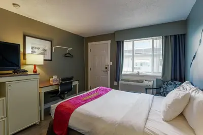a hotel room with a bed and a desk and a window at Ace Motel in Princeton