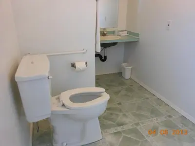 a bathroom with a white toilet and a sink at Mountain Springs Motel & RV Park in Barrière