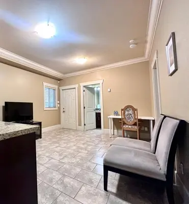 a living room with a chair and a television at Francis Home Hotel \u798f\u6765\u987a\u5bb6\u5ead\u5bbe\u9986 in Richmond
